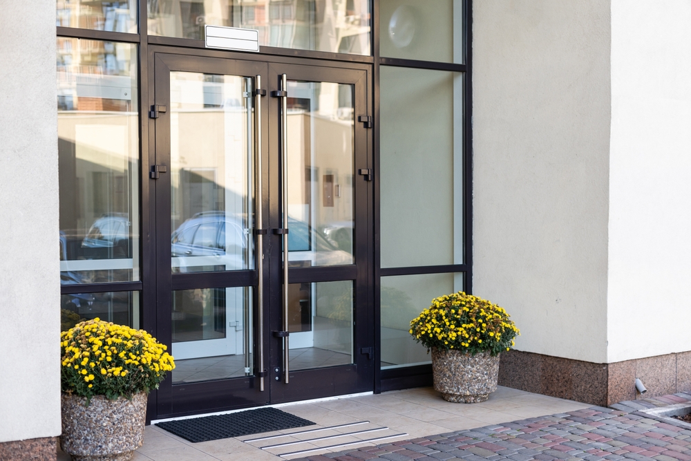 The,Front,Door,Of,A,Office,Block,,Reflecting,Buildings,In